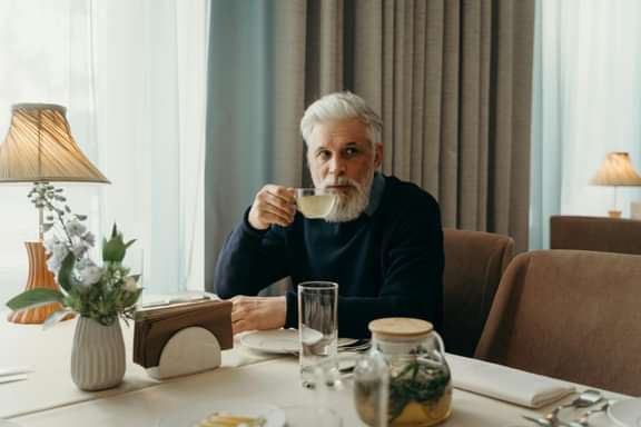 Een betrokken verhuurder drinkt koffie aan tafel